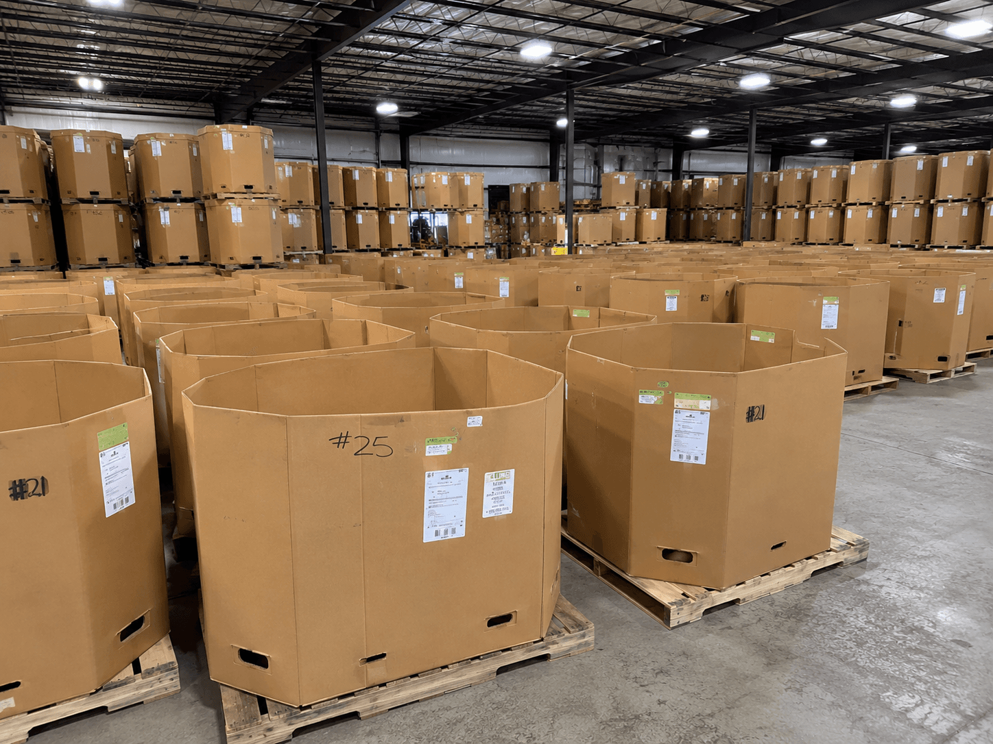 A warehouse full of open-top Gaylord bins on pallets, sorted and numbered