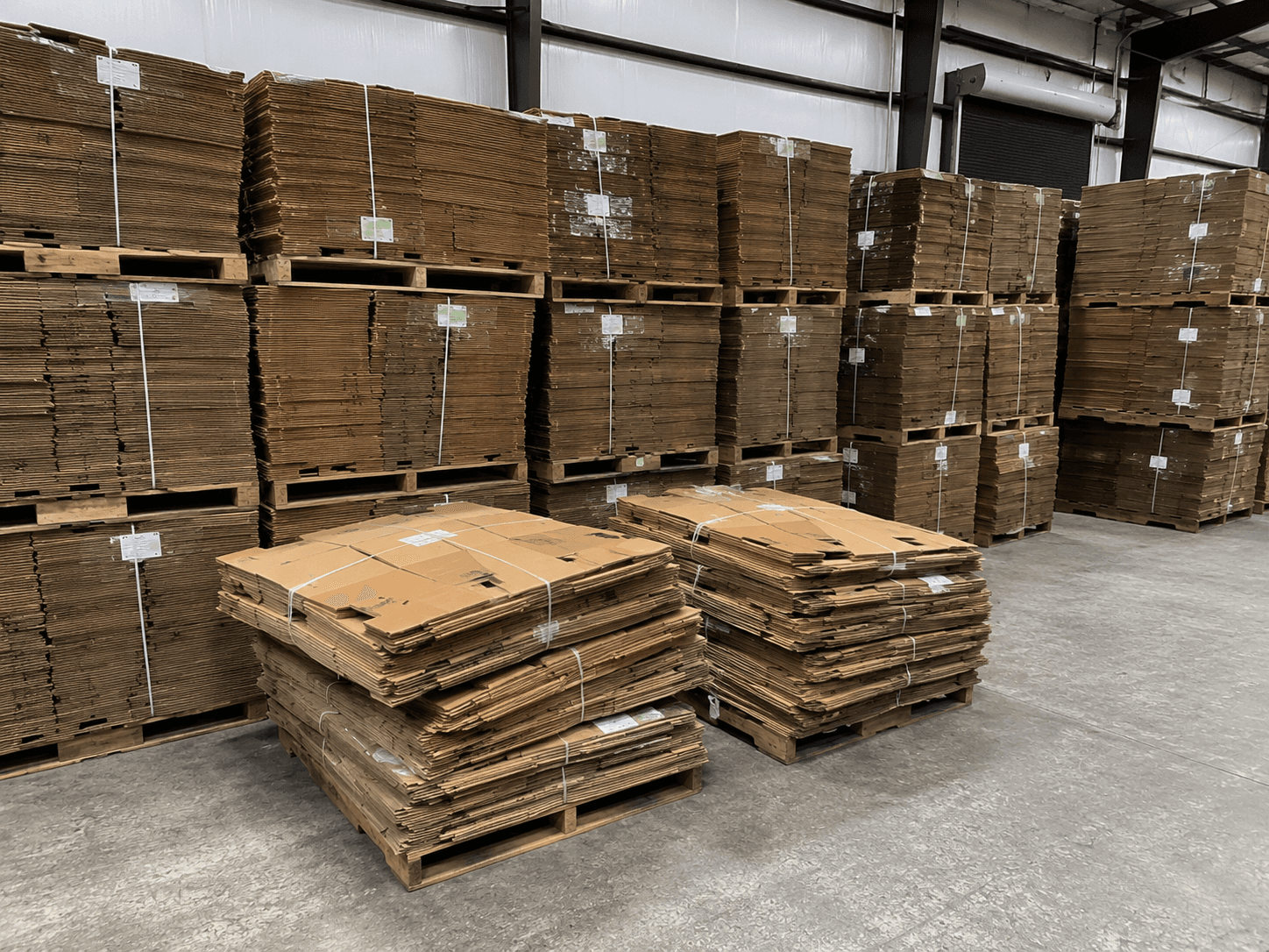 Bundles of flattened Gaylord boxes strapped onto pallets in the warehouse