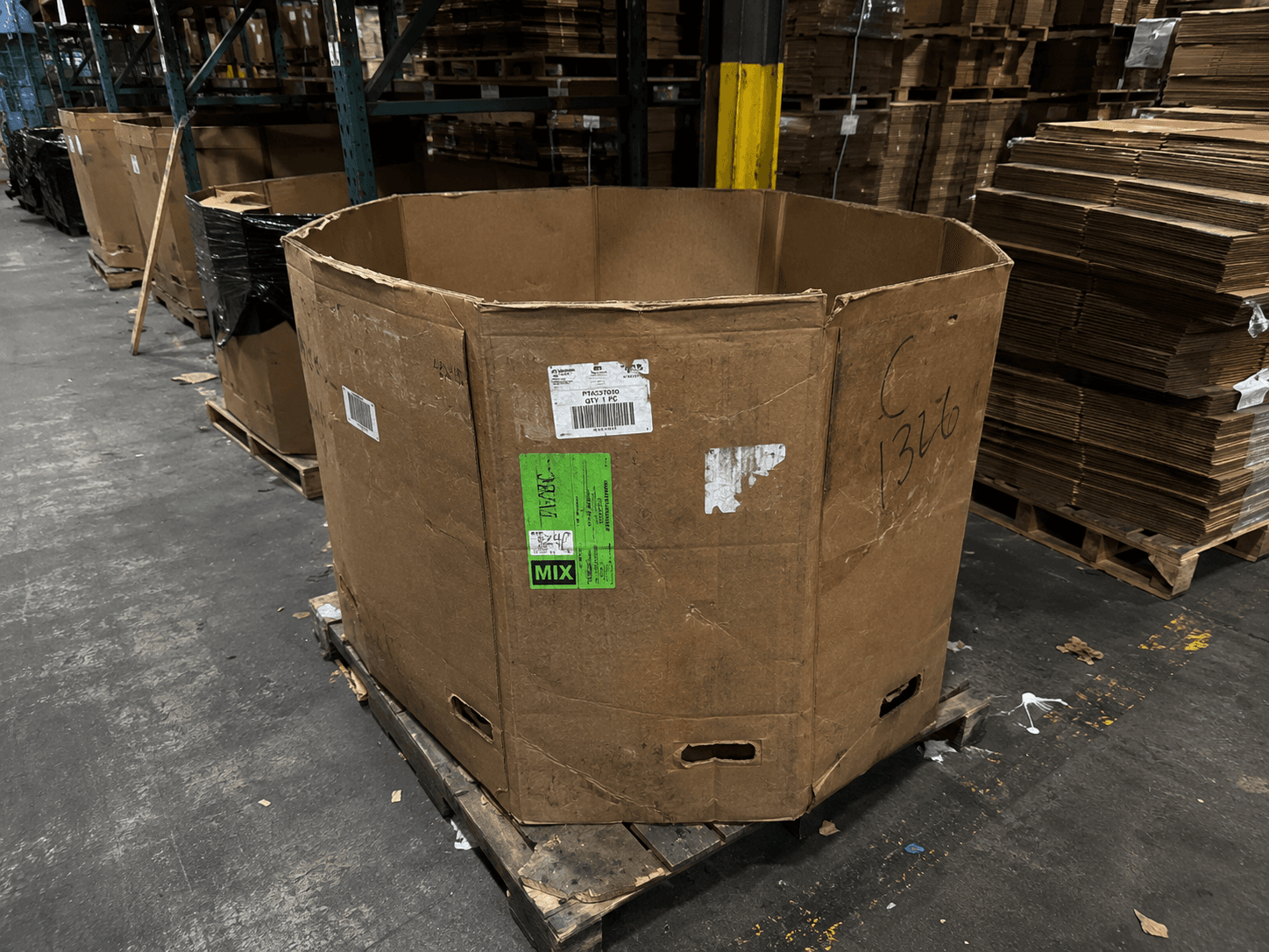 A close-up of a well-used octagonal Gaylord box on a pallet, ready for a second life